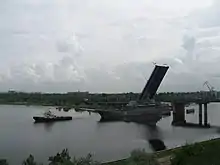 Durchfahrt eines Kriegsschiffes mit einem Schleppboot