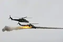 Zwei russische Mi-24, davon einer beim Abfeuern von ungelenkten Luft-Boden-Raketen