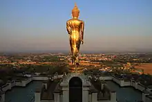 Schreitender Buddha vom Wat Phra That Khao Noi blickt über die Stadt