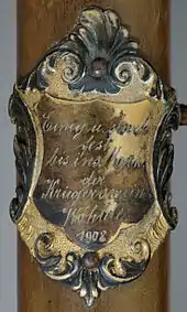 Stockschild bzw. Stocknagel am Fahnenstock des Kriegervereins Wohlde aus dem Jahr 1908