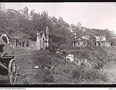 Die zerstörte Kirche und die Schule (rechts)