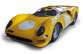 Querformatige Studioaufnahme eines Sportwagens von Ferrari. Der, in einem warmen Gelbton lackierte, zweisitzige Rennwagen mit der Bezeichnung „365P“ hat weiche, fließende Formen und steht vor weißem Hintergrund. Das Modell wurde als Cabrio ohne Verdeck gebaut. In den wuchtigen vorderen Radabdeckungen, die höher als die mittlere Frontverkleidung sind, befinden sich auf jeder Seite drei, mit Plexiglas verkleidete Scheinwerfer. Unten, an der Spitze der Fahrzeugschnauze sitzt ein breiter Lufteinlass, flankiert von zwei aerodynamischen Blechen. Die breiten Rennreifen sind auf mattgrauen Felgen mit chromglänzenden Schnellverschlüssen aus dem Rennsport montiert. Das Cockpit, das sich hinter einer großen halbrunden Windschutzscheibe, mit einem mittig montierten Scheibenwischer befindet, ist ganz in schwarz gehalten. Auf der Fahrertür ist, genauso wie auf der Front, ein großer weißer Kreis lackiert, auf dem die Startnummer aufgebracht wird. An der Heckverkleidung, die direkt hinter den Türen beginnt fallen besonders die zwei großen seitliche Lufteinlässen und eine, über die ganze Fahrzeugbreite gehende Abrisskante am Heck auf. Der kompakte Rennwagen hat eine Länge von knapp über vier Metern, und eine maximale Breite von etwa 180 cm bei einer Höhe von knapp 90 cm.