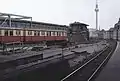 Östli­cher Bahnhofs­kopf mit S-Bahn-Zug der Bau­reihe ET 165 der BVG am Bahn­steig C und dem Stell­werk Frio, Septem­ber 1990