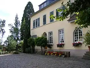 Herrenhaus mit Parkbäumen im Hintergrund