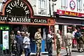 Veteranen und Touristen vor Geschäften in Sainte-Mère-Église.