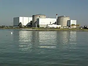 Kernkraftwerk Fessenheim mit den beiden Reaktorgebäuden (grau), davor Gebäude mit Lager- und Abklingbecken für die Brennstäbe, im Vordergrund der Rheinseitenkanal (Aufnahme von Südosten, 2010)