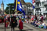 Am Limmatquai, Bannerträger mit Wappen des weissen Hirschs als Wahrzeichen der Fraumünsterfrauen