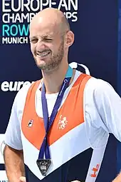Sander de Graaf trägt das niederländische Nationaltrikot über einem weißen T-Shirt. Um den Hals hängt ein blaues Band, an dem die Silbermedaille befestigt ist.