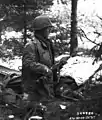 Vom Netzüberzug gab es auch eine Version mit engeren Maschen, die in erster Linie das Glänzen des nassen Helms verhindern sollte (hier Frankreich, November 1944)
