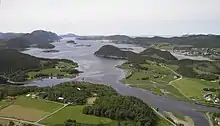 Foto eines Fjords in hügliger Landschaft