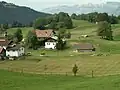 Blick auf einen Teil der Abdeckung der Festung. Vorne rechts Nebeneingang zur Anlage, dahinter ein Panzerturm, links daneben hinter den Bäumen ein Mg-Bunker