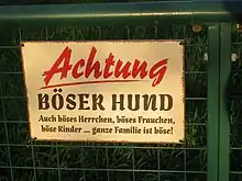 Warnung vor einem Hund, der den Garten bewacht.