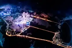 Zu sehen sind hell erleuchtete Lichter von oben. Die Brücke sieht aus wie eine Lichterkette.