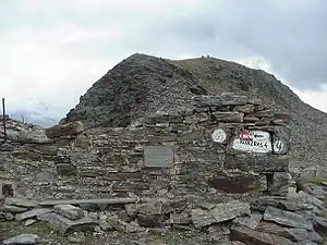Ruine eines Bruchsteingebäudes vor einem Berg
