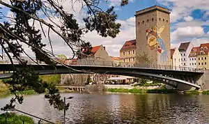Die Dreiradenmühle an der Lausitzer Neiße, mit dem Mosaikgesicht (WAZE)vorne die Altstadtbrücke, im Hintergrund der Zgorzelecer Postplatz