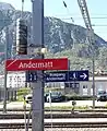 Rotes Bahnhofsschild der Matterhorn-Gotthard-Bahn in Andermatt, Schriftart FF Dax