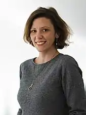 Anikó Glogowski-Merten Abgeordnete des 20. Deutschen Bundestages der Fraktion der Freien Demokraten steht in einem grauen Kleid und einer Kette in einem weißen Tunnel im Paul-Löbe-Haus.