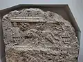 Grabstele mit Relief der Kapitolinischen Wölfin sowie Romulus und Remus, das die Verbindung des Verstorbenen zur Tradition und Kultur Roms betont