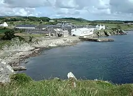 Die Ardbeg-Brennerei mit einigen Häusern der Siedlung Ardbeg im Hintergrund