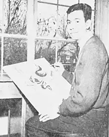 Arthur Amiotte, sitzend, mit einer Bildleinwand und einem Pinsel im Jahr 1965