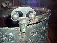 Aylesford bucket, Eimer aus Aylesford, 1. Jahrhundert vor Christus, zwei Gesichtsmasken als Attaschen mit Innenösen zur Aufnahme des Henkels.