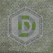 Das Durchsichtsregister auf einer 5-DM-Banknote BBk III (hier im Gegenlicht) ist von Mikroschrift umgeben.