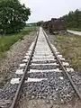 Neu verlegte Schwellen im Bereich eines Bahnübergangs in Bad Laer-Müschen am 20. Mai 2020. Rechts hat man die alten Holzschwellen aufgestapelt.