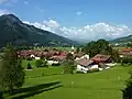 Blick über Bad Hindelang, im Vordergrund der Ortsteil Bad Oberdorf mit der Kirche Unserer Lieben Frau im Ostrachtal und St. Jodokus