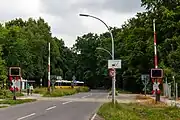 Blick vom Bahnübergang am Bahnhof Johannesstift zur Schönwalder Straße Richtung Spandau, 2015; an der Wendeschleife der heutigen Buslinie M45 befand sich die Kehranlage der Straßenbahn, nach links verlief das Verbindungsgleis zur Bötzowbahn