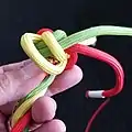 Das nächste Kardeel (gelb) wird nachgesteckt, durch das nächste (rote) Auge. Man bleibt wieder unter dem vorherigen gelbe Kardeel.