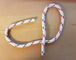 Man knüpft ein Auge, indem man mit der laufenden Part eine Bucht knüpft und diese Part unter die eigene stehende Part durchführt.