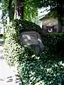 Das Grabmal von Jean Paul und seinem Sohn auf dem Bayreuther Stadtfriedhof: Der Gedenkstein ist ein efeuüberwucherter Findling.