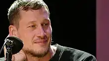 Benedikt Feiten in Nahaufnahme, er blickt leicht seitlich in die Kamera.
