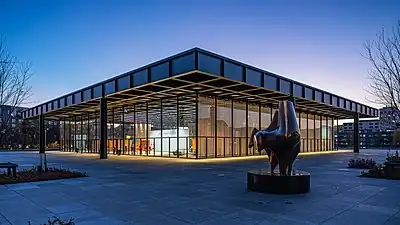 Blick von Süden auf die Bronzeplastik und die Neue Nationalgalerie in der Dämmerung