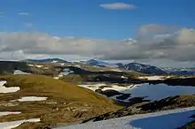 Foto einer Berglandschaft mit vereinzelten Schneefeldern