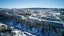 Drohnenbild eines Stadtviertel auf einer Anhöhe mit mehreren Reihen- und Hochhäusern