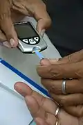 Aufbringen eines Bluttropfens aus der Fingerbeere auf den Blutzuckerteststreifen (2015)