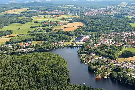Hammersee (2013), im Mittelgrund die Halle der Fertighausfabrik, an der Halbinsel vorn rechts entstand 2018 eine Strandbadelandschaft