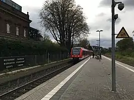 Zug am Haltepunkt Brühl-Kierberg, links das Bahnhofsgebäude