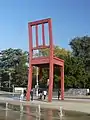 Skulptur broken chair von Daniel Berset, im Hintergrund das Keramikfresko von Hans Erni.