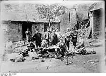 Eine europäische Wandergruppe rastet inmitten chinesischer Steinhäuser.