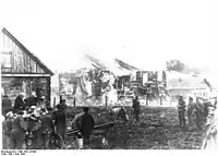 Wehrmachtssoldaten beobachten die von Kollaborateuren niedergebrannte Synagoge. NS-Propagandafoto vom Juni 1941