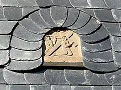 Alte Reliefdarstellung des Kreuzweges Christi - schmückt Schieferfassade