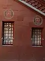 1911 restaurierte Burkhard Mangold (1873–1950) zusammen mit Otto Plattner (1886–1951) die Wandbilder von Wilhelm Balmer (1865–1922) an der Fassade des Basler Rathauses. Mangold und Plattner (mit Brille), verewigten sich als die zwei hinter Gitterstäben zu sehenden Gesichter.