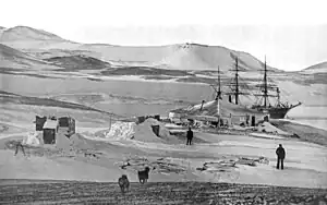Der Hut Point (Vordergrund) mit der in der Winter Quarters Bay eingefrorenen RRS Discovery