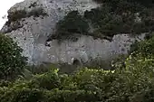 In der Bildmitte, am Boden der Zugang zum Felsgrab