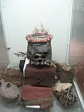 Menschlicher Schädel mit Funeralhelm und Grabbeigaben der Chinchorro-Kultur, ca. 500–1000 n. Chr. (Anker Nielsen Museum in Chile)