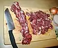 Hacken von Wildbret-Nackenfleisch mit einem Allzweckküchenmesser in Santoku-Form