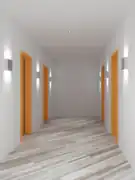 Auch abgeblendete Wandleuchten bringen Licht auf die Wände und lassen einen schmalen Flur dadurch breiter wirken.