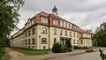 Pflegeheim mit Hauptgebäude (Haus A), Nebengebäude (Haus B), Torbogen als Verbindungsstück zwischen beiden Häusern sowie Einfriedung einschließlich Pfortenhäuschen an der Friedewaldstraße (ehemaliger Wettinstift)